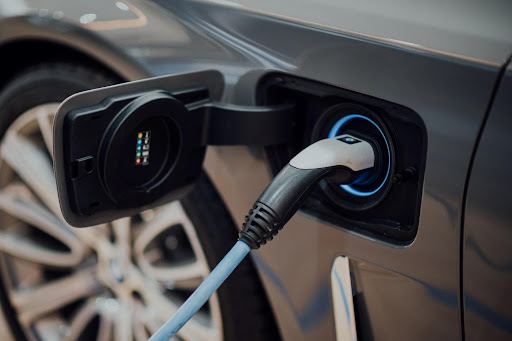 A picture containing an electric vehicle plugged in for a recharge