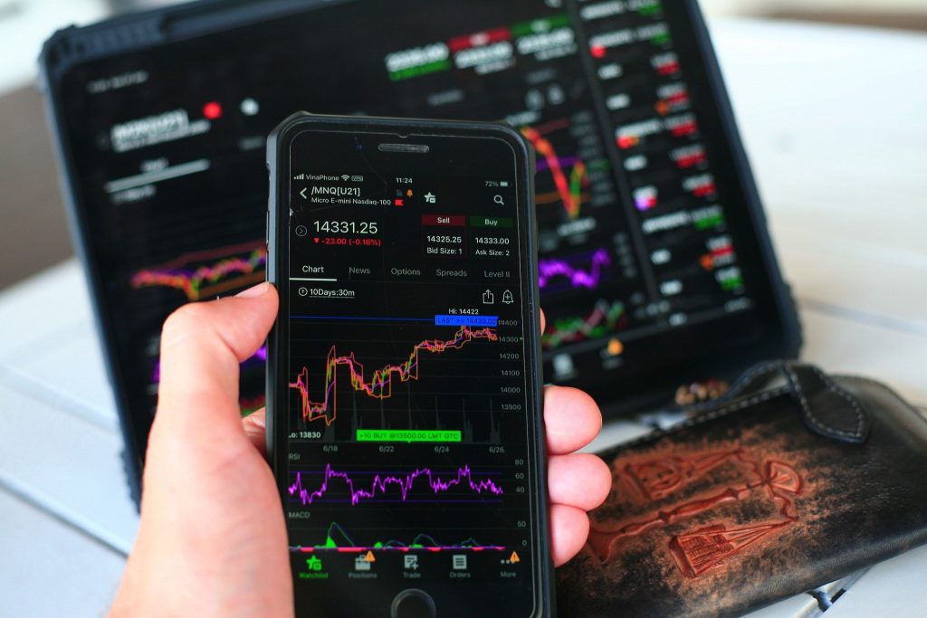 photo showing forex chart comparison on a mobile app and a laptop